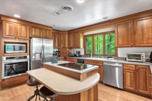 a kitchen with wooden cabinets and stainless steel appliances at Serenity in the Suburbs: Your Gorgeous RVA Getaway in Richmond