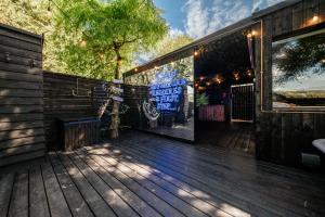 - une terrasse en bois avec un panneau indiquant la bienvenue dans un bar sportif dans l'établissement Wonderland Retreats, à Carnforth