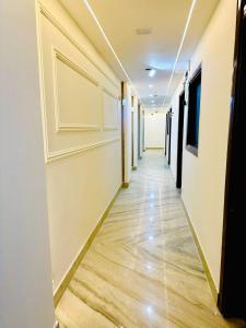 a corridor of an office building with a door and wood floors at Frankstay By Hotel SAMRAT RESIDENCY 10 Mints Walking Distance Nizamuddin Railway Station in New Delhi