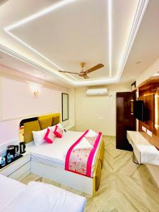 1 dormitorio con 1 cama grande con almohadas rosas en Frankstay By Hotel SAMRAT RESIDENCY 10 Mints Walking Distance Nizamuddin Railway Station en Nueva Delhi