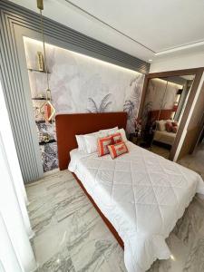 - une chambre dotée d'un lit avec deux oreillers orange dans l'établissement Appertement 2 Bd Willow, à Casablanca