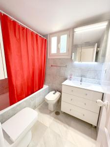 a bathroom with a red shower curtain and a toilet and sink at Los Girasoles in Marina Botafoch in Ibiza Town