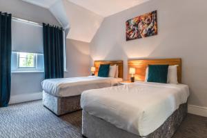 um quarto de hotel com duas camas e uma janela em Plough Hotel em Northampton