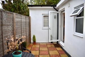 a patio with a white door and a fence at Stylish centrally-located studio with parking in Croydon
