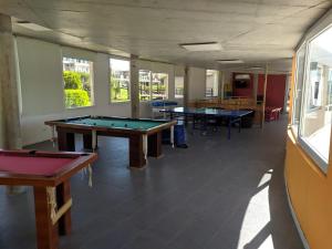two ping pong tables in a room with windows at LINDABAYPLAYA STUDIO in Mar de las Pampas