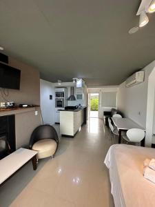 a room with a bed and a living room with a kitchen at LINDABAYPLAYA STUDIO in Mar de las Pampas +4 photos