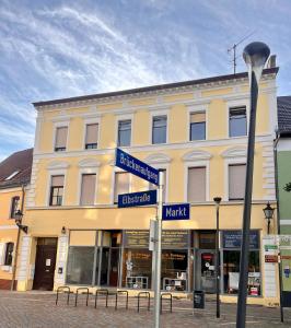 budynek z niebieskimi znakami ulicznymi przed nim w obiekcie Mitten im Herzen w mieście Schönebeck