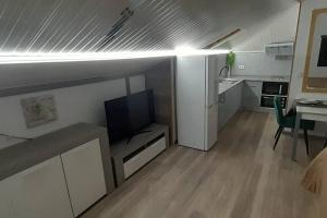 ein Wohnzimmer mit einem TV und einem Esszimmer in der Unterkunft SantoSerenus in Ponta do Sol