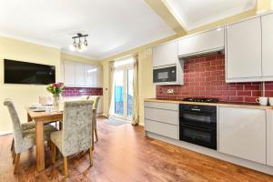 a kitchen with a wooden table and a dining room at 3BR home/Fast Wi-Fi/ Quiet road in Hither Green