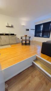 a large room with a wooden floor and a table at Charming 1-Bedroom Apartment in Woolwich in Woolwich