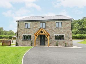 an image of a brick house with a garage at Talarddu Cottage in Builth Wells