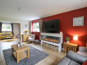 a living room with a fireplace and a flat screen tv at Talarddu Cottage in Builth Wells