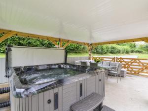 a hot tub on a patio under a tent at Talarddu Cottage in Builth Wells