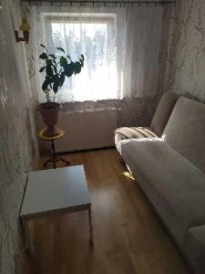 a living room with a couch and a table and a window at Jagiellonka in Inowrocław