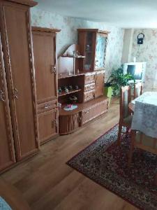 a living room with wooden cabinets and a table with a rug at Jagiellonka in Inowrocław