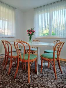 韋萊涅的住宿－Apartma AJDA，餐桌、椅子和花瓶