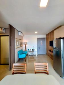 a living room with a refrigerator and a blue chair at Estúdio Alto 22º andar e Elegante no Edifício Vertigo in Campo Grande +15 photos