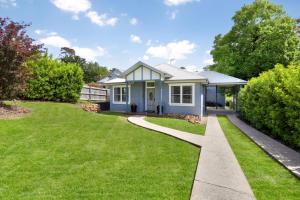 une petite maison bleue avec une pelouse verte dans l'établissement Sofia Rose House only, à Katoomba