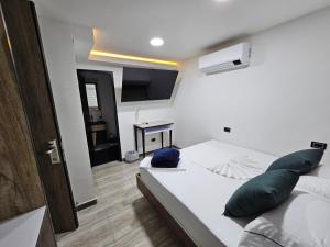 a small bedroom with a bed and a desk at Hostel Boutique Nido de Loros in Medellín