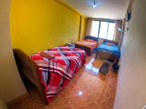 Habitación con 2 camas y pared amarilla. en SKYLAKE B&B en Copacabana