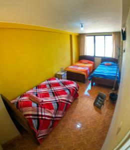 two beds in a room with yellow walls at SKYLAKE B&B in Copacabana