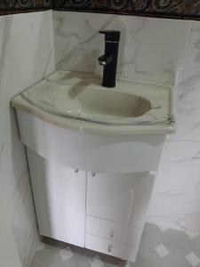 lavabo blanco con grifo negro en el baño en Cabaña los abuelos en Duggan