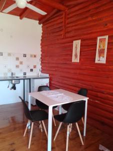 una mesa y sillas en una habitación con una pared roja en Cabaña los abuelos en Duggan