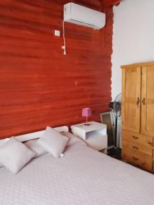 ein Schlafzimmer mit einem weißen Bett und einer Holzwand in der Unterkunft Cabaña los abuelos in Duggan