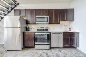 a kitchen with wooden cabinets and a white refrigerator at Sosuite at West Lofts - West Philadelphia in Philadelphia