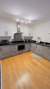 Charming 1-Bedroom Apartment in Woolwich في Woolwich: مطبخ كبير وأرضيات خشبية في غرفة فارغة