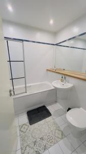 a bathroom with a tub and a toilet and a sink at Charming 1-Bedroom Apartment in Woolwich in Woolwich