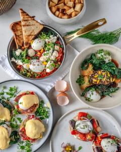 una mesa llena de platos de comida con huevos y tostadas en The Magnolia Hotel & Spa en Victoria