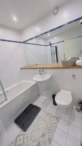 a bathroom with a sink and a tub and a toilet at Charming 1-Bedroom Apartment in Woolwich in Woolwich