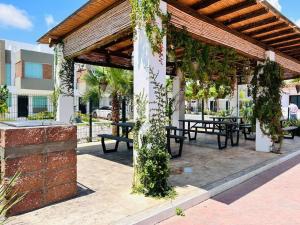 a pavilion with tables and benches with ivy at Portovera B, hermoso depa ideal para familias in Mazatlán
