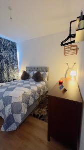 um quarto com uma cama e uma secretária com um candeeiro em Charming 1-Bedroom Apartment in Woolwich em Woolwich