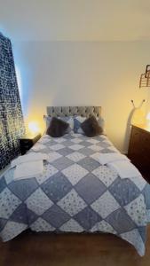 Charming 1-Bedroom Apartment in Woolwich في Woolwich: سرير ازرق وبيض عليه وسادتين