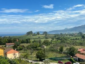 a view of a village with cars parked on a hill at EL PALOMAR DE GÜERRES in Colunga