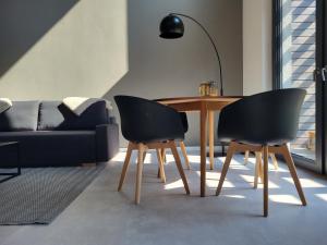 a table and chairs in a living room with a couch at Ferienhaus Schlossterrassen 4b in Pouch +10 photos