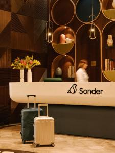 Quelques valises debout devant un comptoir dans l'établissement Sonder Business Bay, à Dubaï