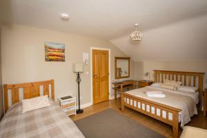 1 Schlafzimmer mit 2 Betten, einem Schreibtisch und einer Lampe in der Unterkunft Kilcatten Lodge in Kilbrittain
