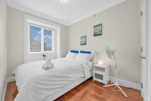 um quarto branco com uma cama branca e uma janela em Luxurious Getaway in Vancouver-Private room with attached bathroom em Vancouver