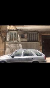 In ibrahimia midtown Alex في الإسكندرية: سيارة فضية متوقفة أمام مبنى