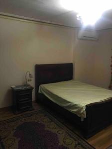 een kleine slaapkamer met een bed en een nachtkastje bij In ibrahimia midtown Alex in Alexandrië