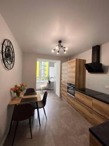 a kitchen and dining room with a table and chairs at Стильна чудова квартира в місті Тернопіль in Ternopilʼ
