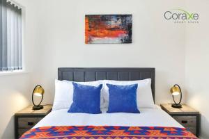 een slaapkamer met een bed met blauwe kussens bij 3 Bedrooms Modern Retreat for Contractors and Families by Coraxe Short Stays in Oldbury