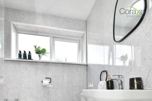 een badkamer met een wastafel en een spiegel bij 3 Bedrooms Modern Retreat for Contractors and Families by Coraxe Short Stays in Oldbury