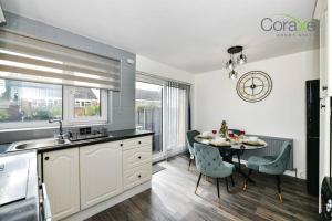 a kitchen with a table and a dining room at 3 Bedrooms Modern Retreat for Contractors and Families by Coraxe Short Stays in Oldbury