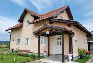 a pink house with a white door at Villa Lady Di Plitvice in Vrhovine