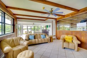 sala de estar con sofás y ventilador de techo. en Cocoa Beach House on Banana River Walk to Ocean!, en Cocoa Beach
