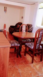 sala de estar con mesa de madera y sillas en Departamento Independiente en Tacna, en Tacna